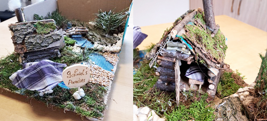 aus Naturmaterialien selbstgebautes Miniatur-Paradies mit Holzhütte und Fluss